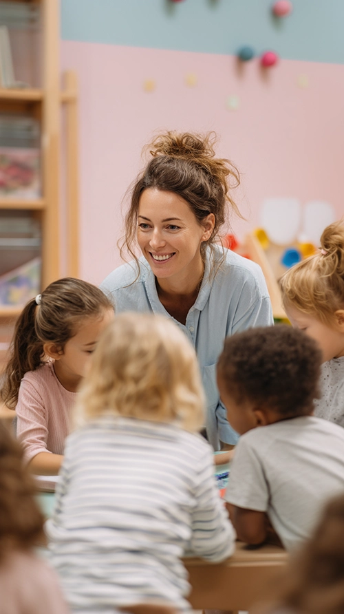 Éducatrice de jeunes enfants souriante accompagnant un groupe d’enfants
