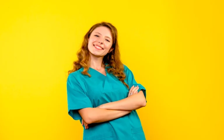 Aide soignante souriante posant sur un fond jaune