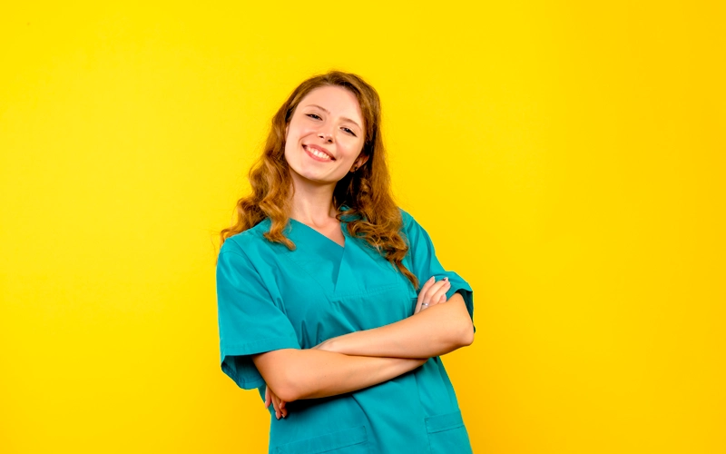 Aide soignante souriante posant sur un fond jaune