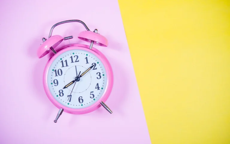Horloge rose sur fond jaune et rose