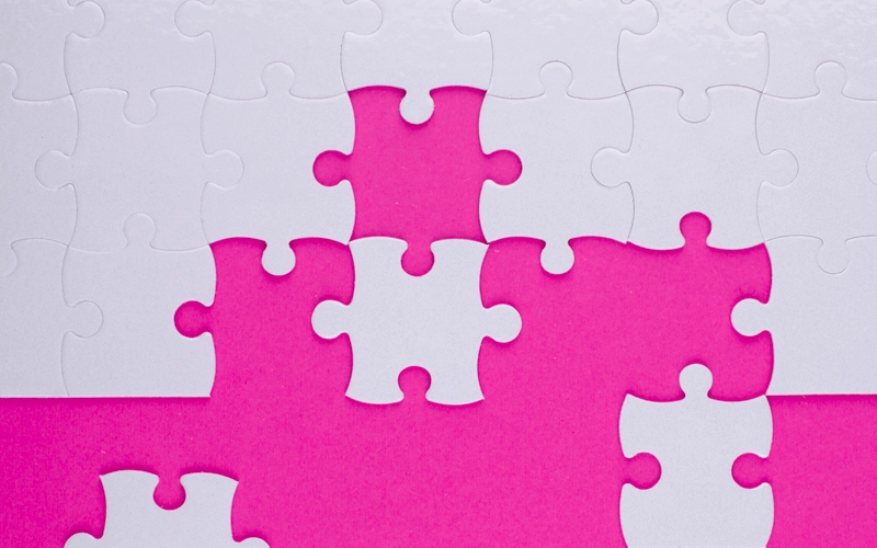 pièces de puzzle blanches sur fond rose