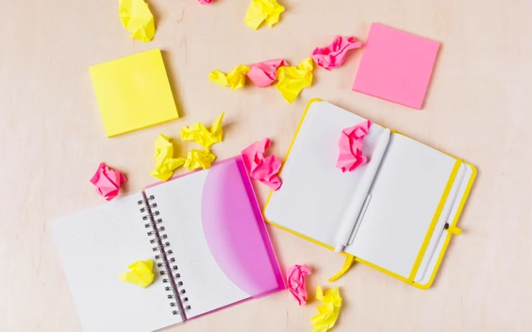 Agendas et post-it froissés sur un bureau