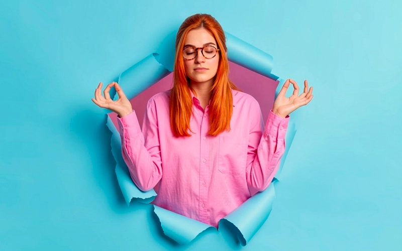 Jeune femme les yeux fermés en posture de relaxation