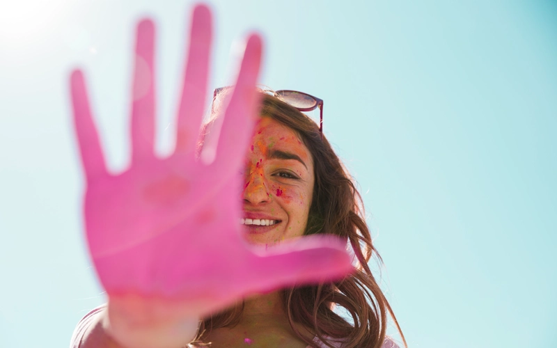 femme montrant la paume de sa main peinte en rose