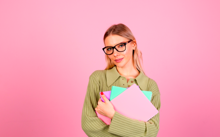 femme tenant des documents sur fond rose
