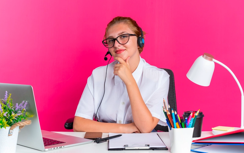 Jeune femme avec casque assise à son bureau devant son ordinateur